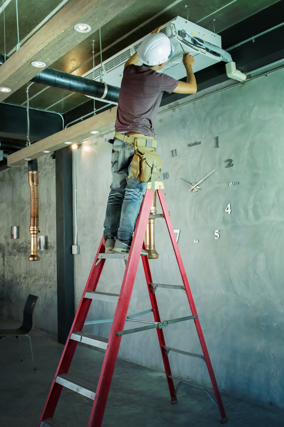 Service Man Technician Repairing Air Conditioner on the Ceiling